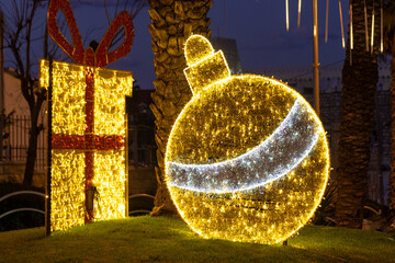 Beautiful street decorations of a giant Christmas tree ball ornament and a gift box  in Wadi Nisnas the Christian neighborhood in Haifa, Israel
