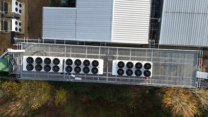 Aerial drone top down rotating view of cooling and ventilation systems on a data storage center warehouse building showing modern infrastructure.