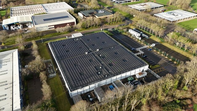 Aerial drone view of large scale cutting-edge technology and futuristic infrastructure of a large-scale data center in Milton Keynes, UK. AI cloud quantum computing.  - Powered by Adobe