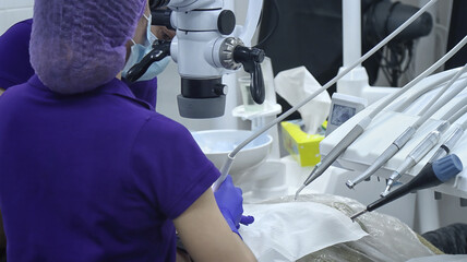 Dentist working with a microscope in a modern dental clinic