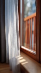 Warm sunlight illuminating a sheer curtain and window creating soft shadows indoors