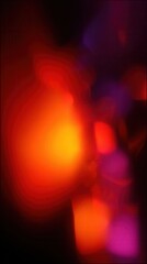 Abstract warm red, orange, and purple lights creating a blurring bokeh effect in the dark