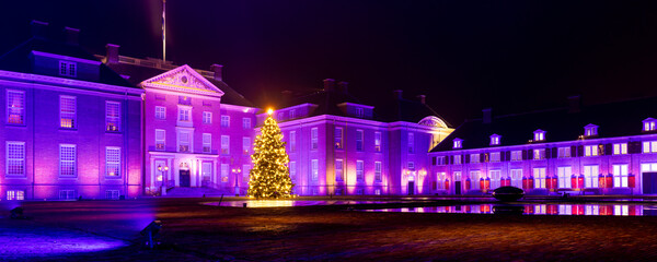 Apeldoorn, The Netherlands - December 20, 2025: Panoramic view of Royal Palace het Loo, National museum, illuminated in pink colors during Christmas period in Apeldoorn, The Netehrlands