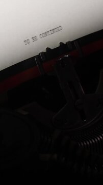 Vertical video typewriter machine presenting to be continued typed text on a white sheet, signifying an ongoing story, cliffhanger, suspense, or the indefinite continuation of an event or narrative