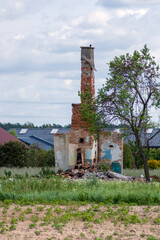 Ruiny starego domu z czerwonej cegły wysokim kominem.