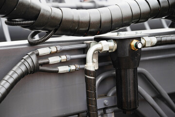 Spiral cable connecting truck cabin and trailer. Pneumatic hoses and electric cables