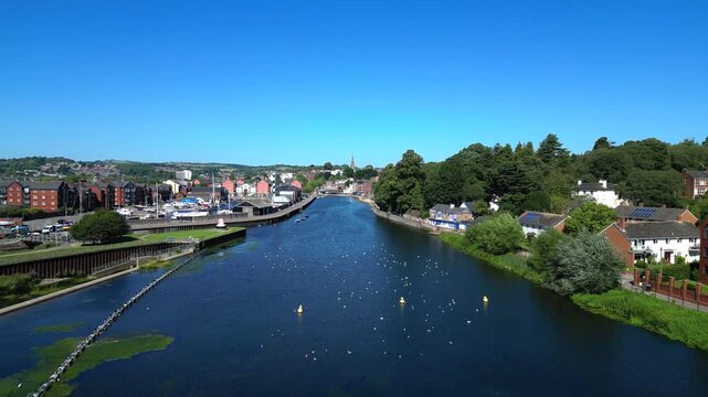 Exeter, South Devon, England: DRONE VIEWS: Low angle shots of the River Exe and Exeter Quays showing commercial and residential buildings and, finally, Trews Weir. Exeter is a cathedral city. 