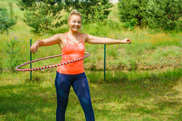 Young woman with hoola hoop outdoors