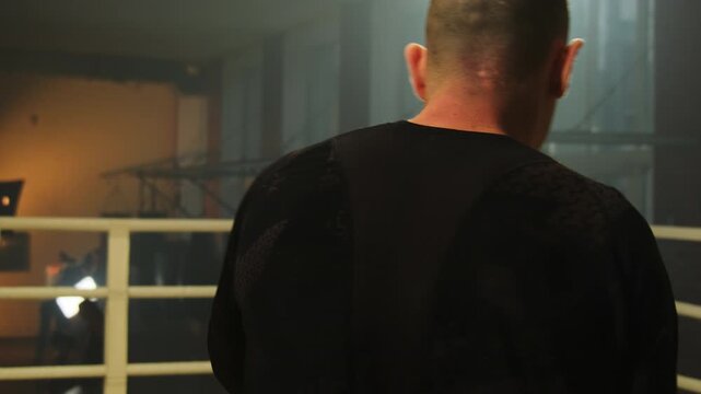 Man performs shadow boxing simulating real fight in ring. Boxer practices punches and hones skills concentrating on technique of performing exercise