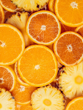 Fresh sliced orange and pineapple fruit pattern texture background top close up