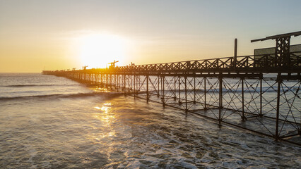 Fototapeta premium Summer sunset at the port of Pimentel, with a view of the pier in Chiclayo, Lambayeque, on the Peruvian coast