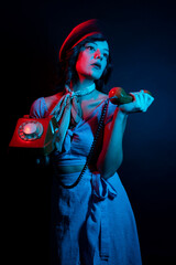 Young Woman Talking on a Retro Phone in a Neon-Lighted Studio Environment - Communication Concep