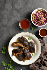Pork ribs served with sauce and red cabbage salad