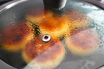 Golden Pancakes Cooking Under Lid with Steam and Condensation
