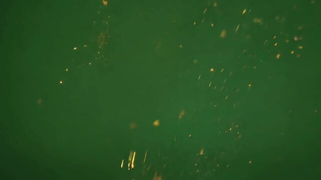 Golden fire sparks falling and flying on green screen, realistic welding or firework particles for visual effects overlay, hot burning ember shower.