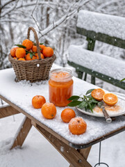 tangerines and tangerine jam on a frozen bench