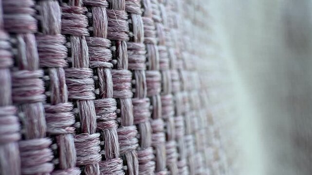 Close-up of a woven fabric texture with a soft, muted color palette. The intricate patterns create a visually appealing design.