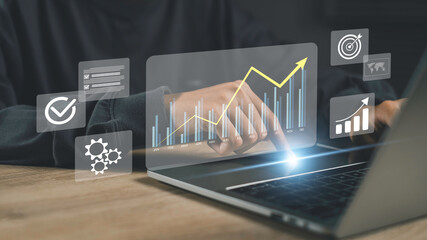 Businessman using a futuristic dashboard interface with financial graphs and data analytics, symbolizing investment growth, digital transformation, and strategic financial management.