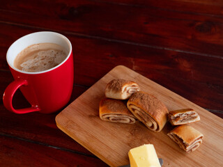 Cozy breakfast with cinnamon rolls, fresh butter and a cup of coffee