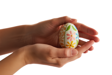 Close-up of a person's hands gently holding a beautifully decorated Easter egg with colorful floral patterns on a white background.