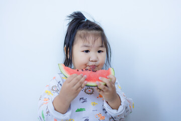 Cute Asian little girl eating watermelon,Lovely little girl eating watermelon,Adorable little Asian child girl Eating Watermelon isolated on White Background.