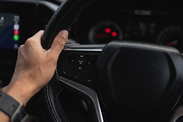 Human hands holding a car steering wheel,A man holding the steering while driving an expensive car....