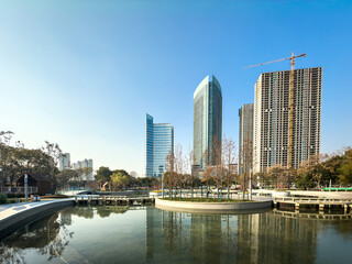 Obraz premium Modern Urban Landscape with Skyscrapers and Serene Water Reflection