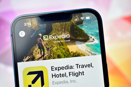 Closeup of smartphone displaying expedia travel app interface with scenic travel image