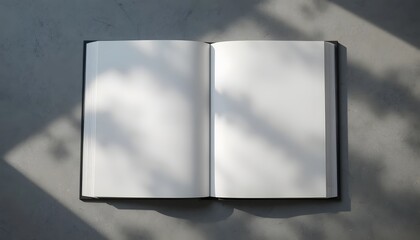 An open book with blank pages casting shadows and sunlight on a textured surface