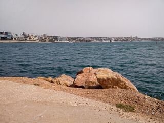 Cascais, Portugal. Rocks against the backdrop of the city from the ocean.