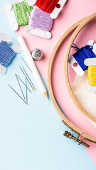 Colorful embroidery supplies arranged on a pastel background with tools and threads for crafting