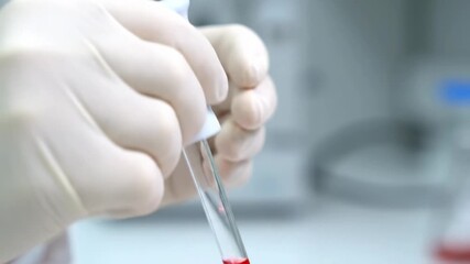 Scientist hands in gloves dropping red liquid from pipette Lab research - Powered by Adobe