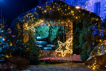 D&eacute;corations de No&euml;l install&eacute;es dans une rue du village de Locronan en Bretagne, &eacute;l&eacute;ments lumineux et fa&ccedil;ades en pierre cr&eacute;ant une ambiance nocturne festive et chaleureuse.