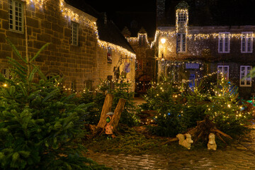 Fa&ccedil;ades en pierre et d&eacute;corations lumineuses dans une rue du village de Locronan en Bretagne &agrave; l&rsquo;occasion des f&ecirc;tes de No&euml;l, ambiance nocturne calme et authentique.