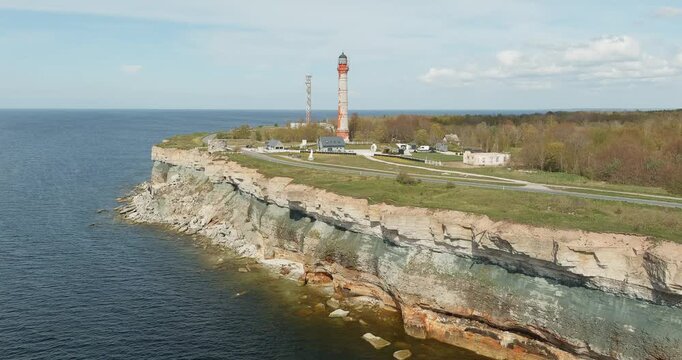 Aerial view of Pakri lighthouse and Pakri old lighthouse on the edge of a high limestone cliff, located on the Pakri peninsula, in sunny spring weather with clouds in the sky, Estonia.