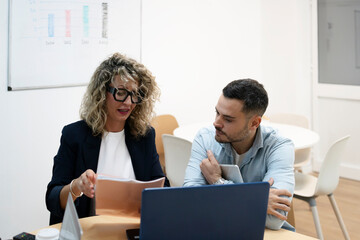 Business colleagues discussing work in a corporate office meeting