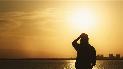 Lonely Figure Watching Sunset By The Sea  at Sunset