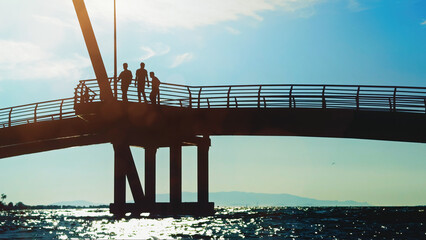 People Standing On Pier At Sunset