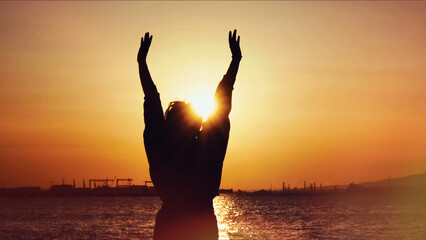 Person Raising Arms To The Sun At Sunset