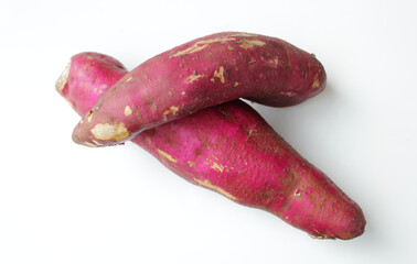 Two raw sweet potatos on white background. Horizontal food shot with copy space, great for healthy eating, nutrition education, organic food marketing, agriculture or farm content, and vegan lifestyle
