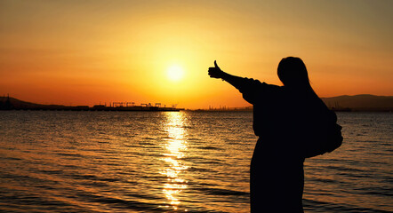Woman Pointing Toward The Sea At Sunset