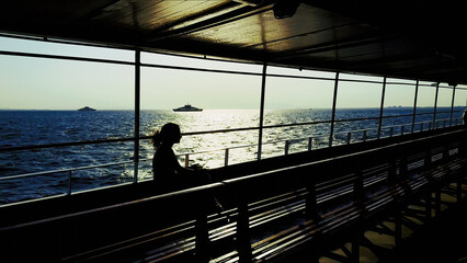 Woman Silhouette Sitting On Ferry With Sea View At Sunset
