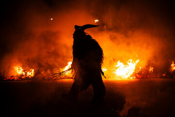 Krampus in the midst of flames is a demonic being that accompanies the religious folkloric figure. This tradition is linked to Christian mythology.