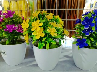 Colorful artificial flowers in pots