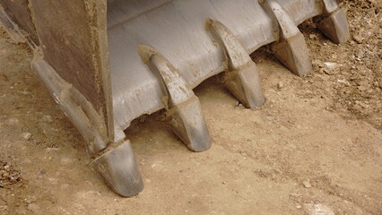 metal excavator shovel teeth against the ground
