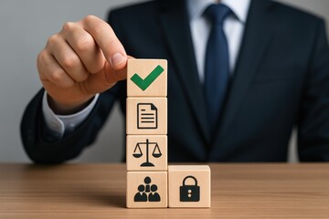Businessman stacking wooden blocks with legal and security icons on a desk compliance