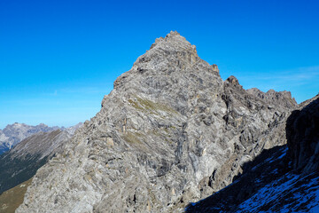 Obraz premium Wild Lechtal Alps with rugged peaks and a tranquil alpine mountain lake.