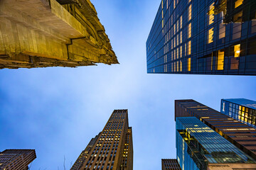 Upward view of modern skyscrapers against blue evening sky in New York City