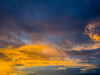 Beautiful sky view at sunset or sunrise with orange clouds and blue sky background. Sky landscape at dusk.