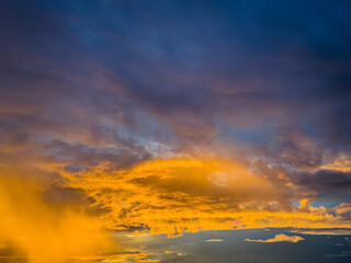 Beautiful sky view at sunset or sunrise with orange clouds and blue sky background. Sky landscape at dusk.